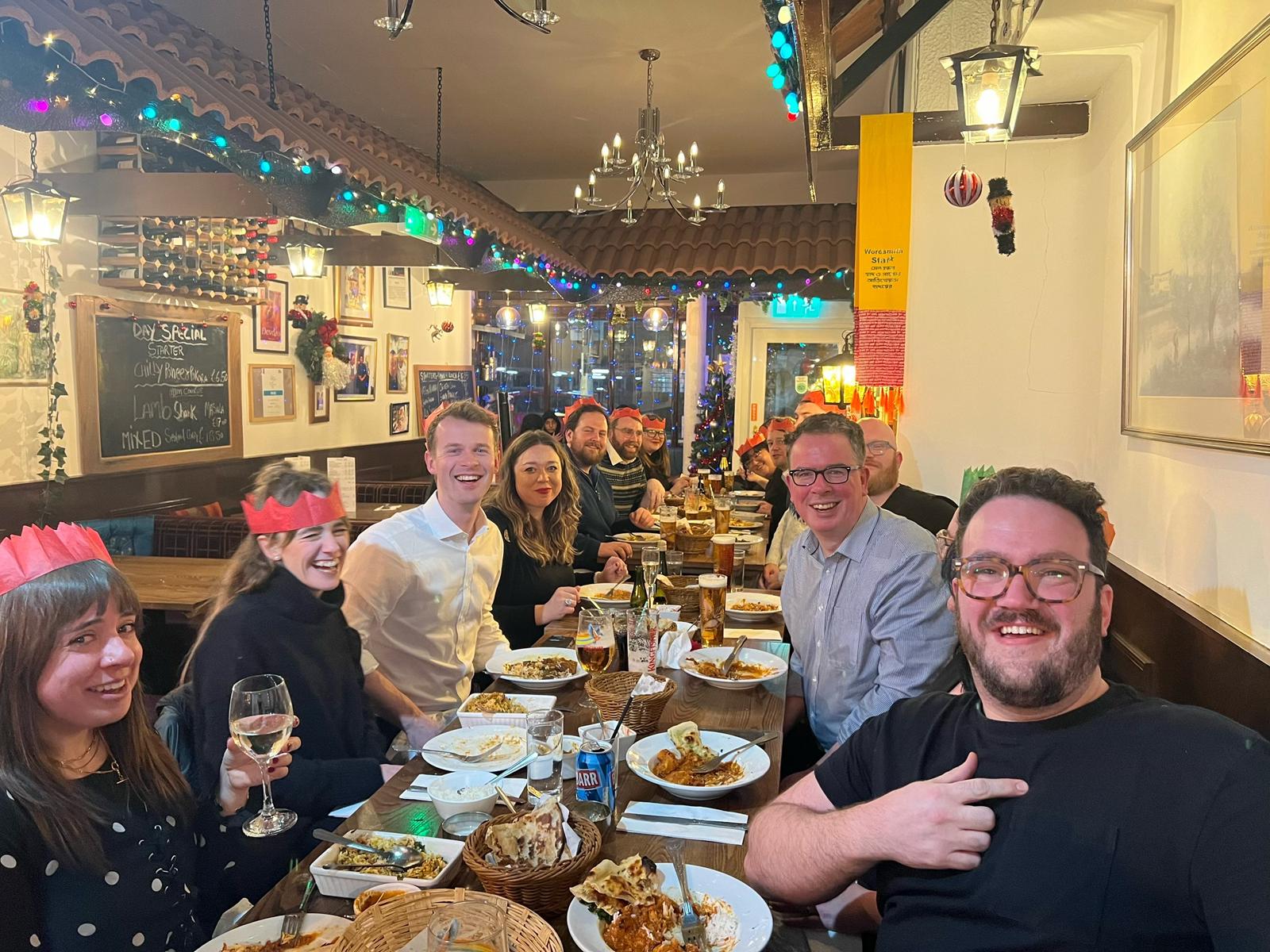 Friends enjoying a festive group dinner at Curry Cottage